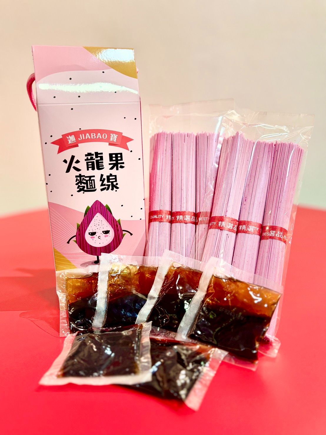 1.	天然色彩<br />火龍果的紅色果肉含有天然色素，能賦予麵條迷人的色澤，無需人工添加色素。<br />2.	口感與風味<br />火龍果麵通常口感滑順Q彈，有淡淡的甜味或果香，搭配本店隨包附贈的老薑麻油及香辣椒麻調味包風味絕佳。<br />3.	環保與可持續性<br />火龍果在盛產期常因供過於求而導致浪費，我們以創新的方式充分利用這些資源，不僅減少浪費，還為農業創造更多附加價值，實現環境友好與永續發展。