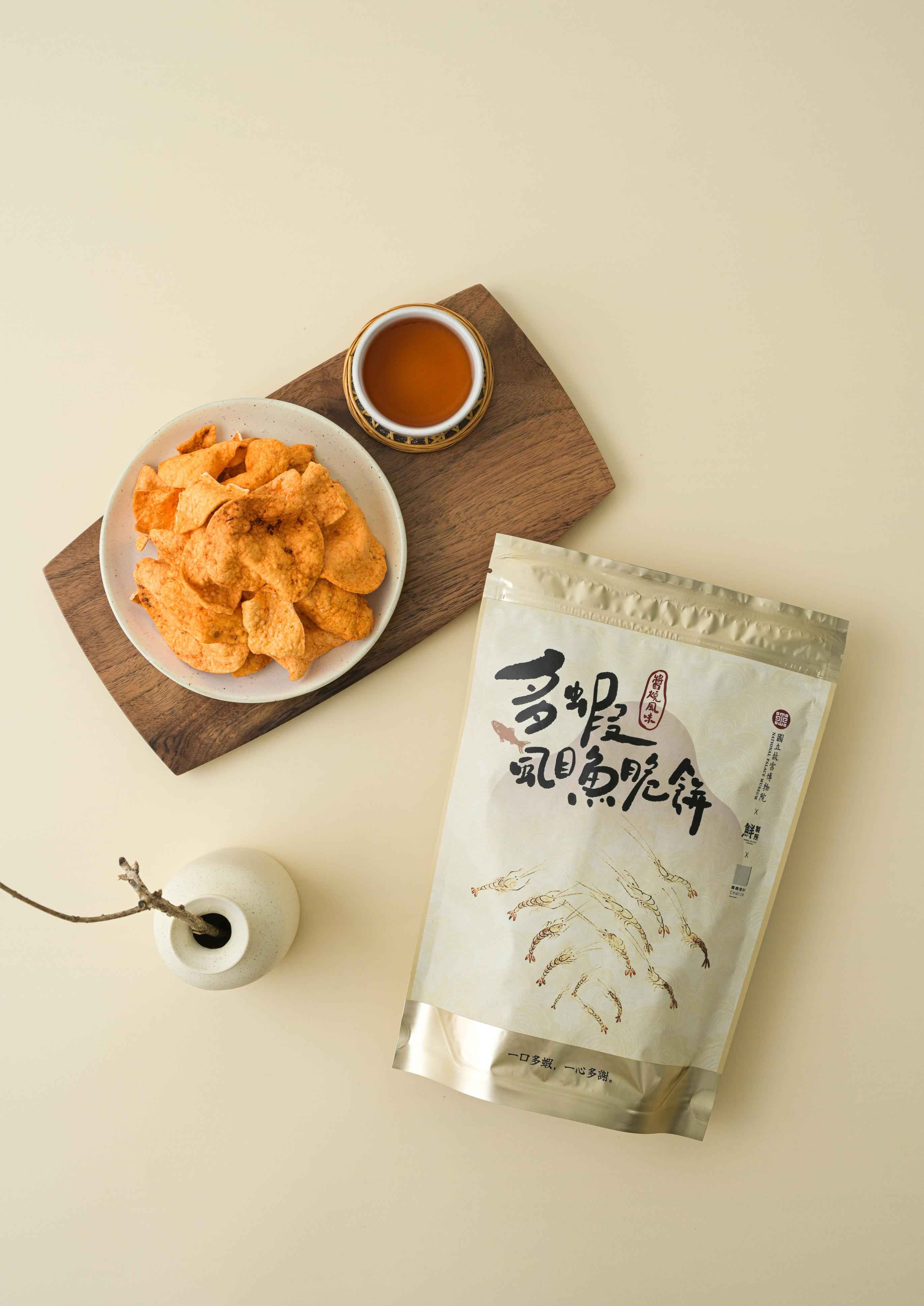 本設計融合台灣在地海味,兼具趣味性與文化性,適合日常零食、親友分享,亦是展現地方特色的伴手禮首選。
<br />
<br />本產品以布袋在地特產——虱目魚與白蝦為主要原料,採低密度友善養殖方式製成口感香酥脆口的脆餅零食,鮮味濃郁,是融合產地風味與日常零食樂趣的雙鮮美味。