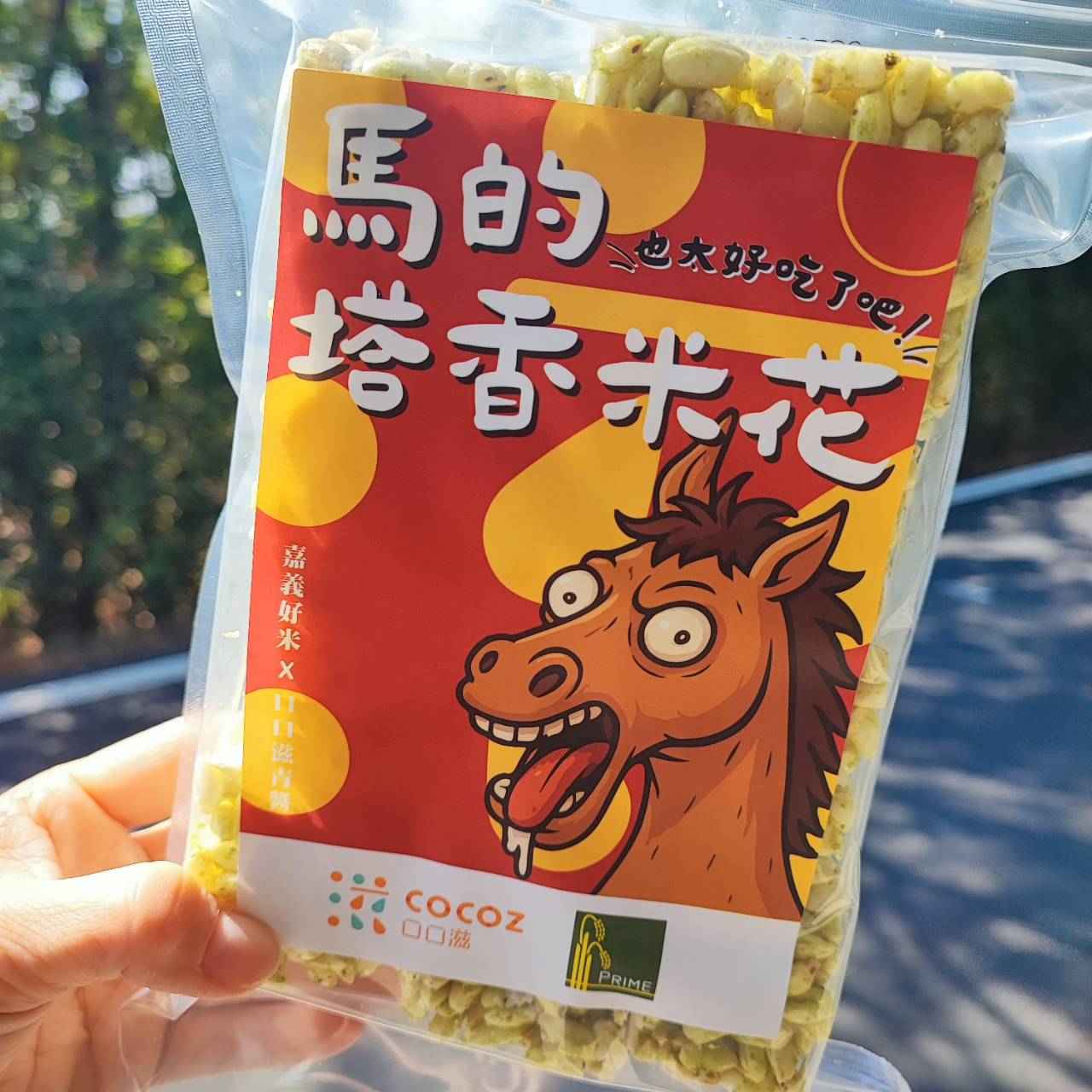 以嘉義好米爆製為酥脆米花，搭配口口滋招牌純青醬（九層塔青醬），呈現米花與草本香的獨特風味。開發動機在於結合嘉義好米與在地青醬，打造適合全年齡、具節慶感與伴手禮價值 的在地特色點心。